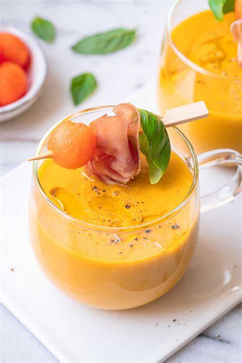 Glas mit kalter Melonensuppe und Basilikum