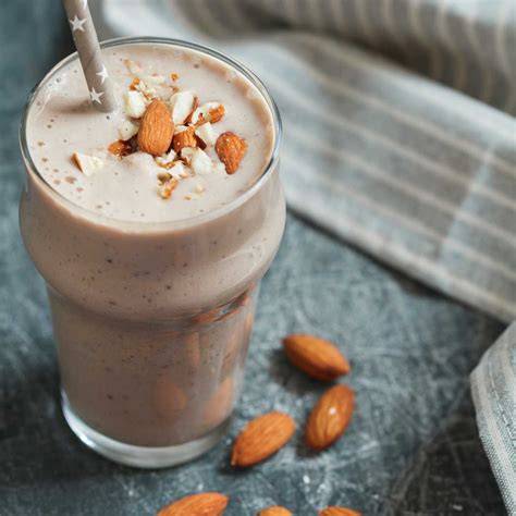 Glas mit schokoladigem Smoothie und Mandeln garniert
