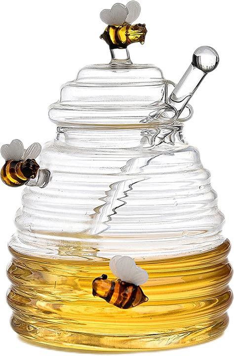 Glas naturbelassener Honig, Löffel, Blüten