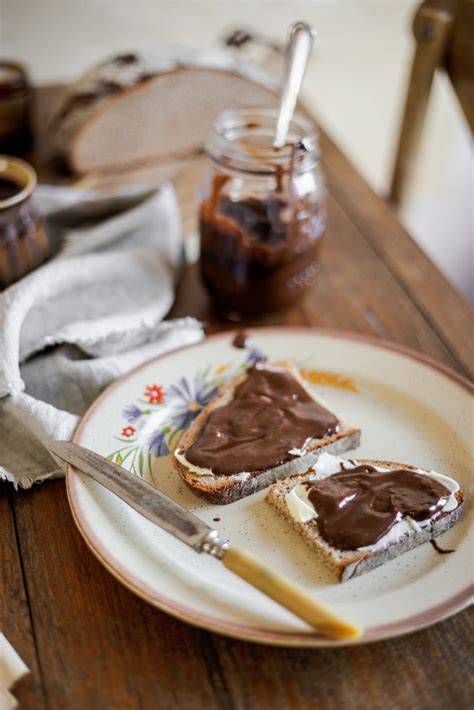 Glas vegane Nougatcreme auf Frühstückstisch