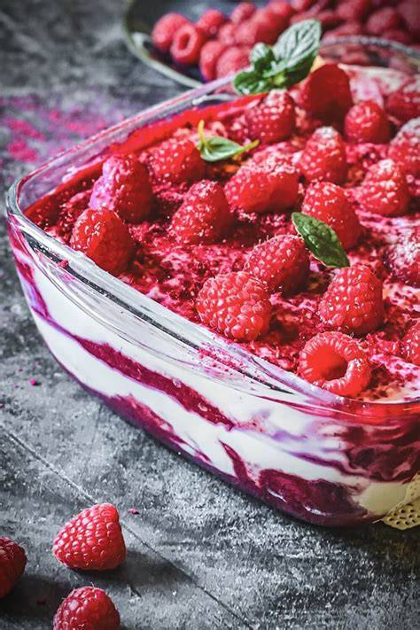 Glasdessert mit gefrorenen Himbeeren und Creme