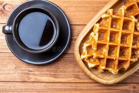 Glasflasche Cola neben einer frisch gebackenen Waffel auf Holztisch