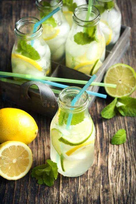 Glasflaschen mit Zitronen-Limonade und Minze