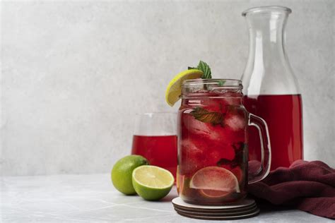 Glaskaraffe mit Hibiskus-Eistee, Gurke und Limette