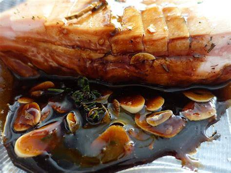 Glasur aus Honig und Balsamico beim Anrichten des grünen Spargels