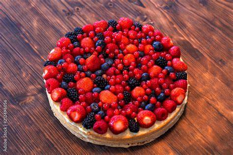 Glutenfreier Obstkuchen auf einem Holzbrett mit Beeren