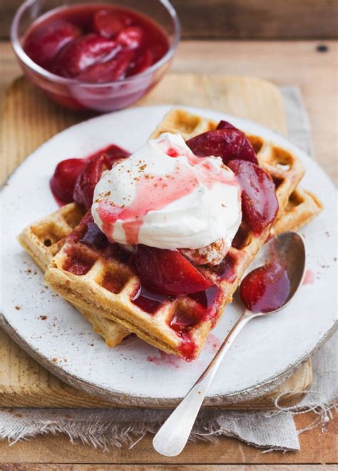 Goldbraune Waffeln mit Pflaumenkompott und Walnüssen auf einem Frühstückstisch