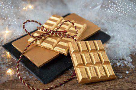 Goldene Dulcey Schokoladentafel vor dunklem Hintergrund