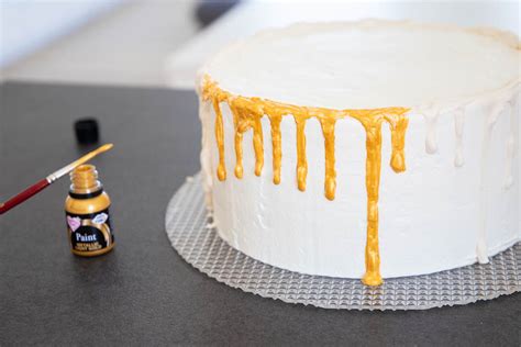 Goldene Fondant-Verzierung auf einer Torte mit Pinsel aufgetragen
