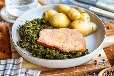 Grünkohl mit karamellisierten Kartoffeln und Kassler auf einem Teller