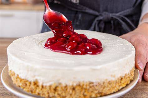 Granatapfel-Quark-Kuchen auf Keksboden, angerichtet mit rubinroten Kernen