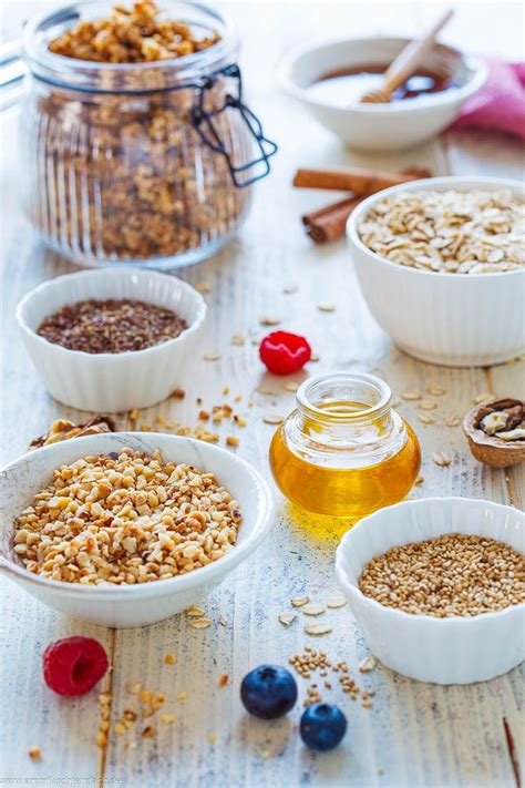 Granola-Zutaten: Haferflocken, Nüsse, Samen, Honig auf rustikalem Hintergrund