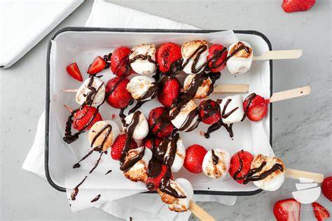 Grillspieße mit Marshmallows und Erdbeeren auf einem Grillrost