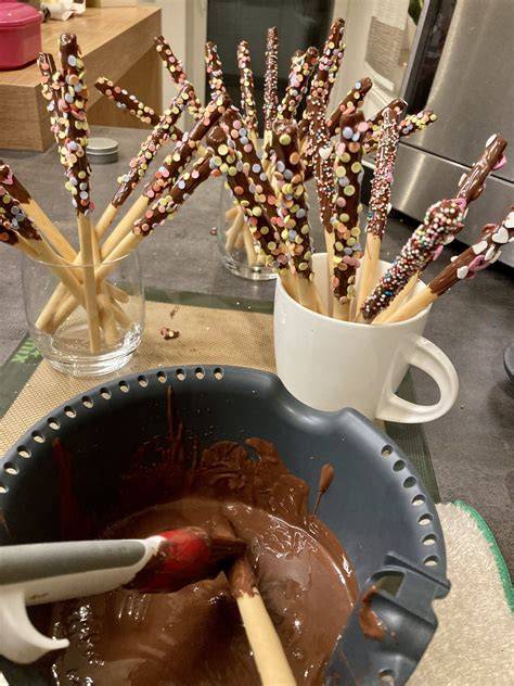 Grissini mit Schokolade auf Backpapier, Zuckerperlen