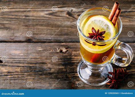 Grog im Becher mit Zimtstange und Zitronenscheibe