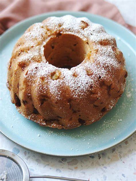 Gugelhupf mit Apfelstückchen und Eierlikörguss auf Kuchenplatte