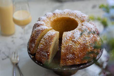 Gugelhupf mit Puderzucker und Eierlikörflasche als Stillleben