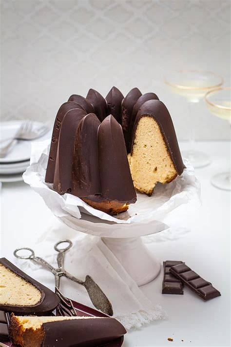 Gugelhupf mit Schokoladenglasur und Nussdekor auf Kuchenplatte