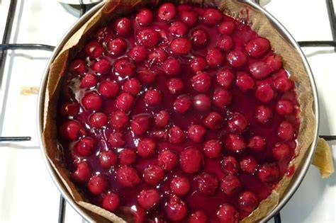 Guss kochen: Topf mit rotem Tortenguss und Kirschen, daneben Springform