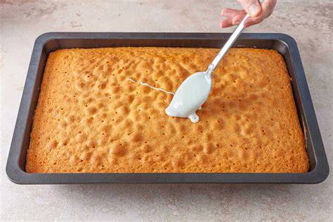 Guss wird mit einem Löffel auf dem Kuchen verteilt