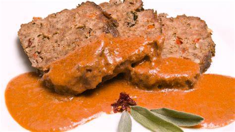 Hackbraten vom Blech mit Paprika und Käse, angerichtet auf Holzbrett