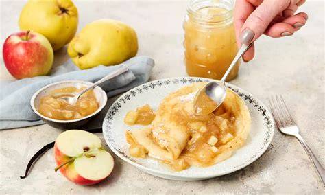 Hand öffnet festgewordene Marmelade mit Löffel und gibt Apfelsaft hinzu