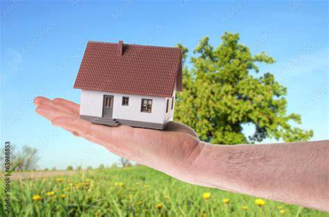 Hand hält ein Haus in der Handfläche - symbolisiert persönliche Betreuung