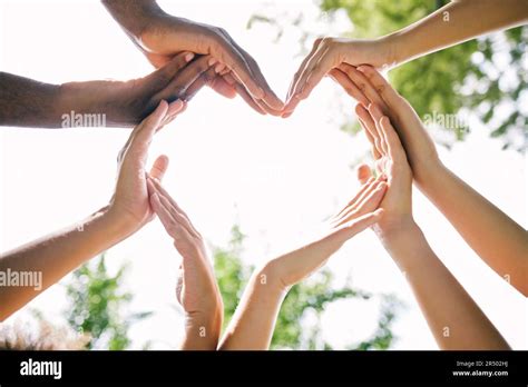 Hand hält eine Gruppe von Menschen im Kreis zusammen - symbolisiert Gemeinschaft und Betreuung