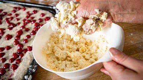 Handgemachte Streusel in Schüssel und auf Kuchen verteilt