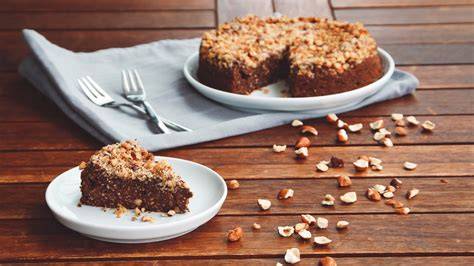 Haselnuss-Nougat-Kuchen, Zutaten und servierter Kuchen auf Holzbrett