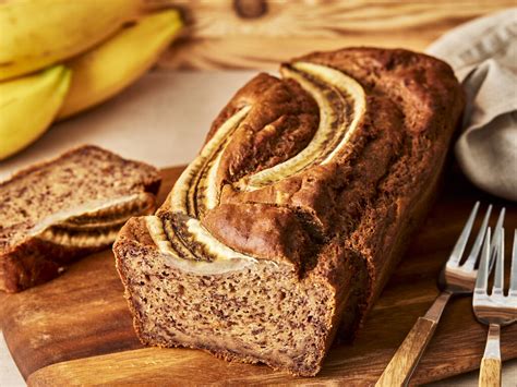 Hausgemachte Bananen-Müsliriegel ohne Zucker auf einem Holzbrett, Zutaten rundherum