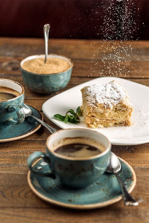 Hausgemachter Birnen-Joghurt-Kuchen aufgeschnitten mit heißem Kaffee serviert