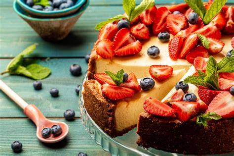 Hausgemachter Käsekuchen auf Kaffeetafel mit frischen Beeren
