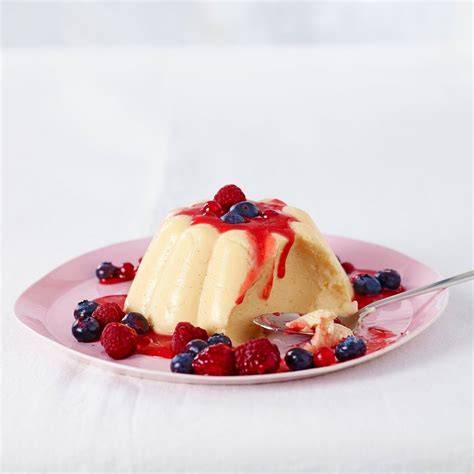 Hausgemachter Vanillepudding mit Beerensauce dekoriert
