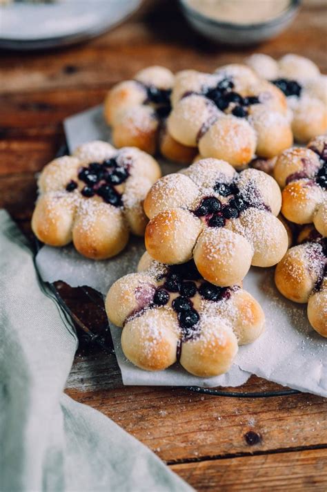 Hefeblume mit Vanillepudding-Füllung und Blaubeeren auf rustikalem Holzbrett