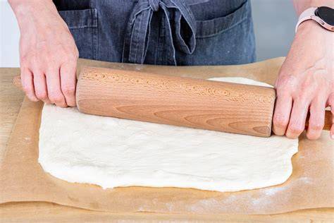 Hefeteig ausrollen und auf das Blech legen