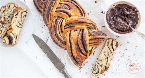 Hefezopf mit Schokofüllung frisch gebacken auf Holztisch mit Deko