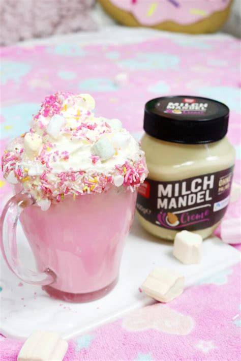 Heiße Einhorn-Schokolade in bunten Gläsern, verziert mit Marshmallows und Zuckerstreuseln