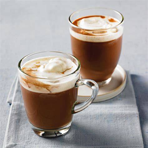 Heißer Kakao mit Rum und Sahne neben Kuchenscheiben
