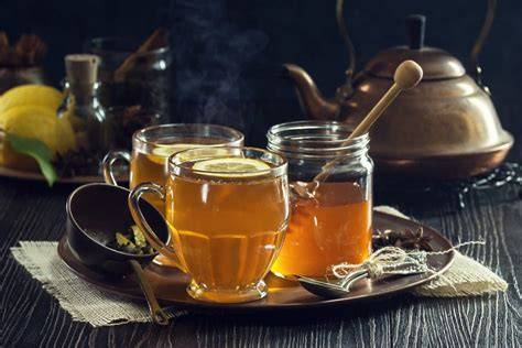 Heißes Getränk mit Whisky, Zitrone, Honig und Gewürzen in gemütlicher Winteratmosphäre
