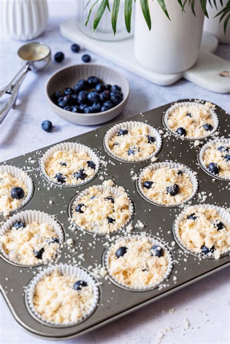 Heidelbeer-Muffins mit knusprigen Streuseln auf Etagere, frische Beeren und Minze