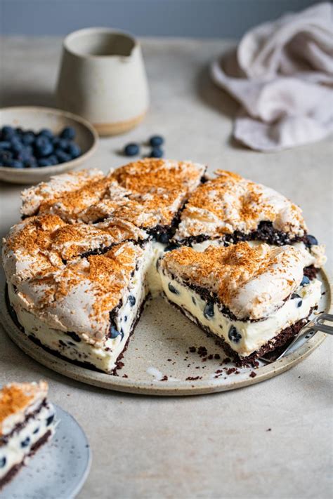 Heidelbeer-Schoko-Kuchen angerichtet auf Tortenplatte mit Blaubeeren und Zartbitterstückchen