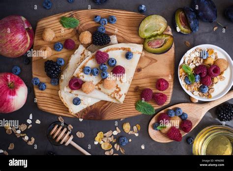 Heidelbeer-Weiße-Schokolade-Kuchen auf rustikalem Holzbrett mit frischen Beeren
