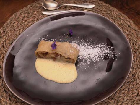 Heidelbeerstrudel serviert auf Teller mit Vanillesauce