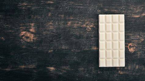 Helle, cremige weiße Schokoladentafel auf Holztisch