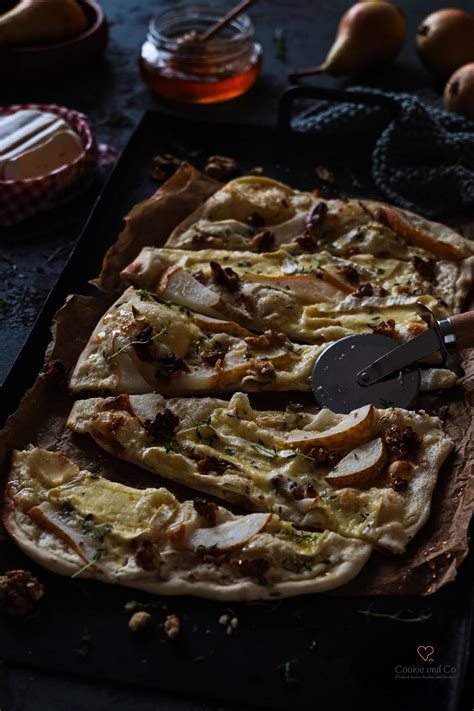 Herbstlicher Flammkuchen mit Birnen, Camembert, Walnüssen und Honig auf Holzbrett