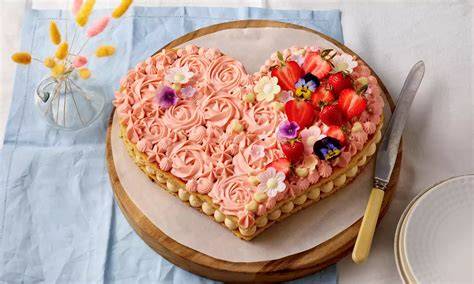 Herzförmige Torte mit pinken Rosetten und Himbeerfüllung