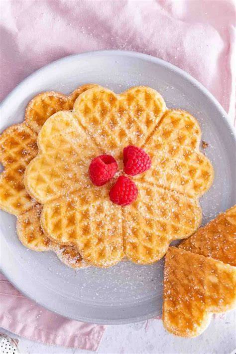 Herzwaffeln auf Teller mit Himbeeren