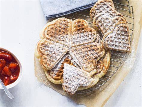 Herzwaffeln auf einem Gitter mit Puderzucker