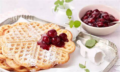 Herzwaffeln mit Puderzucker und Kirschen